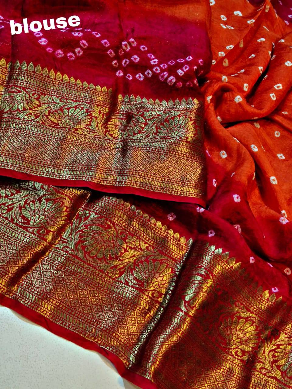 Red saree with gold and pink patterns on a white background