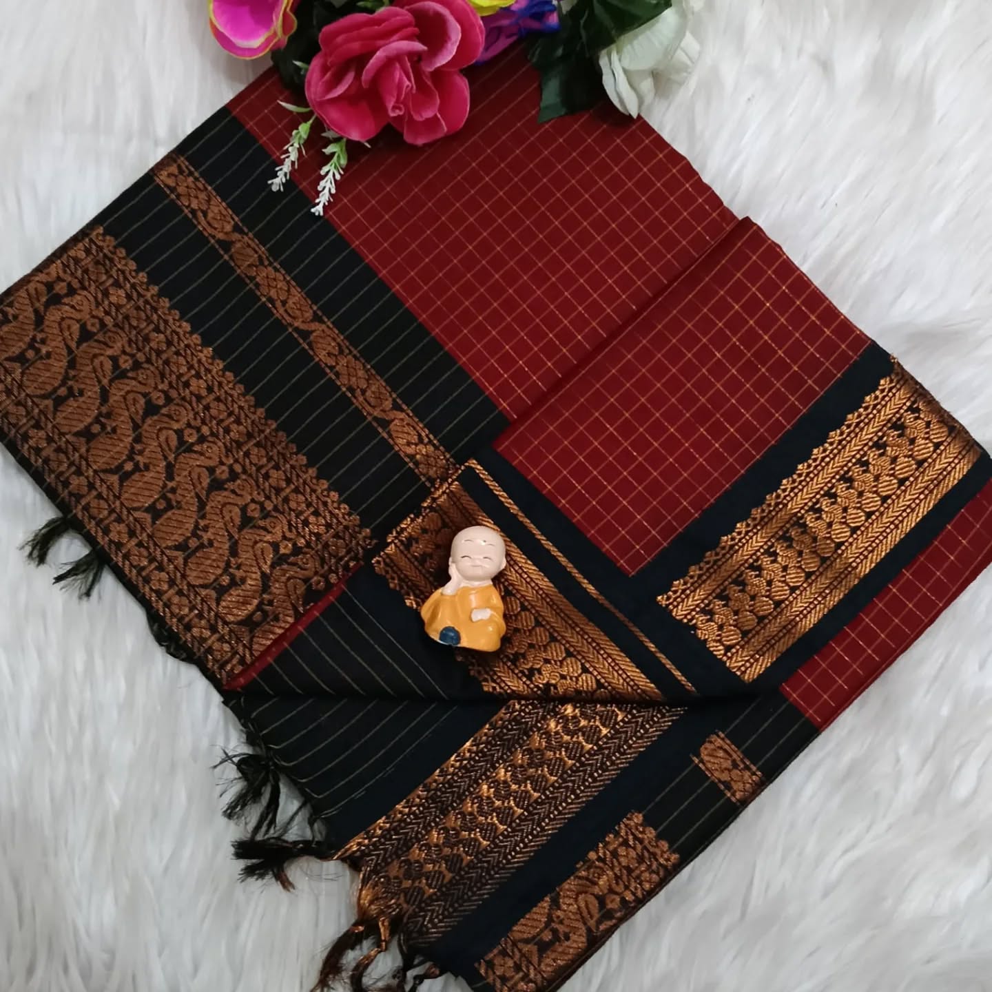 Red and black patterned fabric with gold accents on a white background