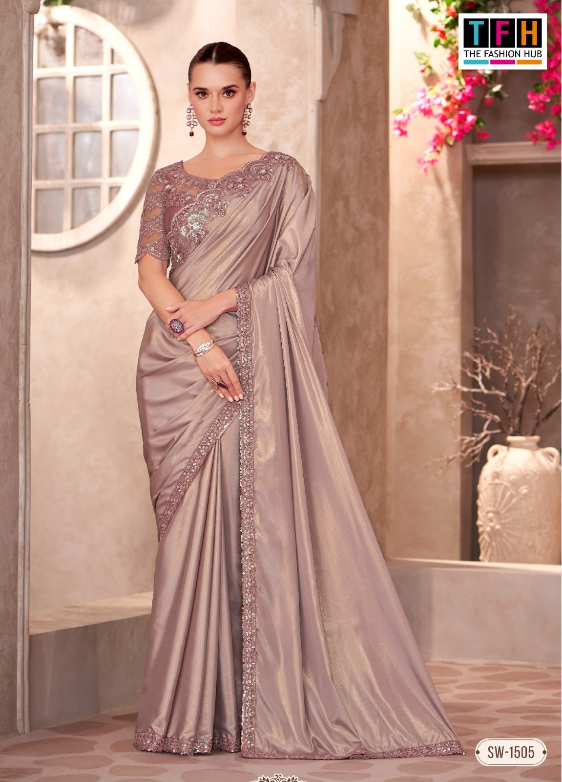 Woman wearing a gray saree with a matching blouse in a decorated indoor setting.