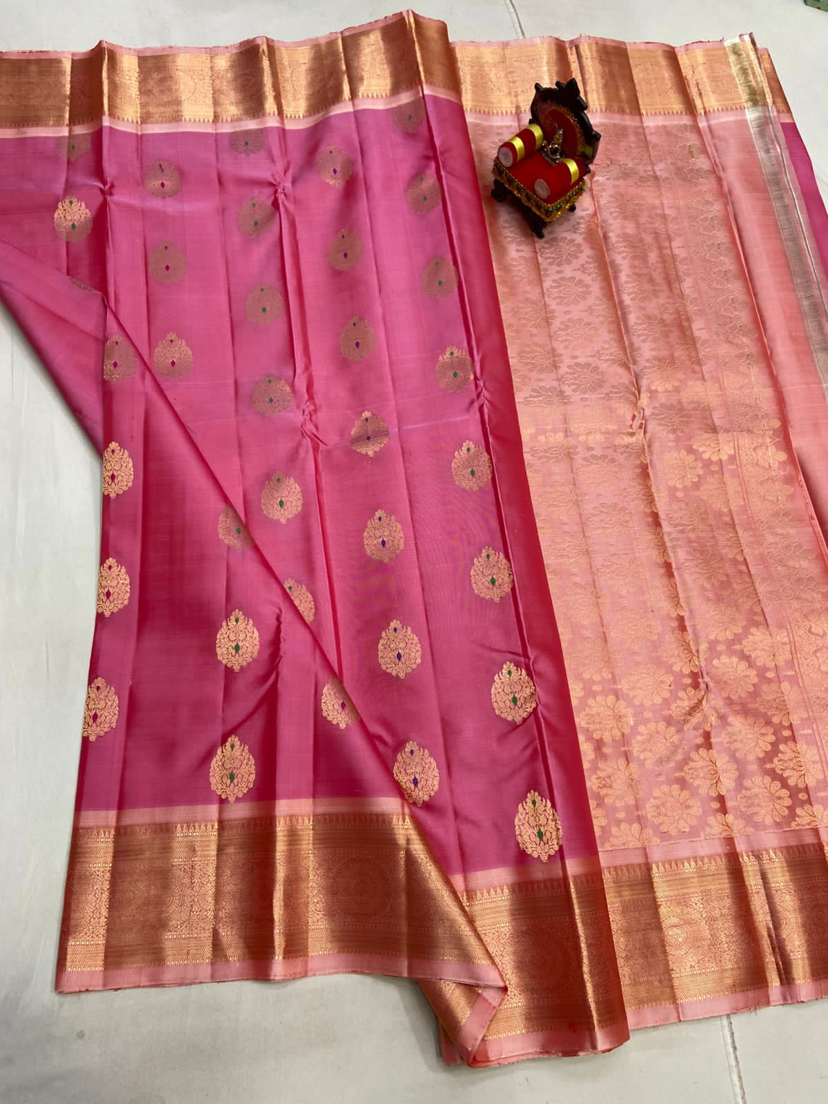 Pink saree with gold patterns on a white background