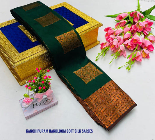 Green and brown Kanchipuram handloom saree with decorative box and flowers on a white background