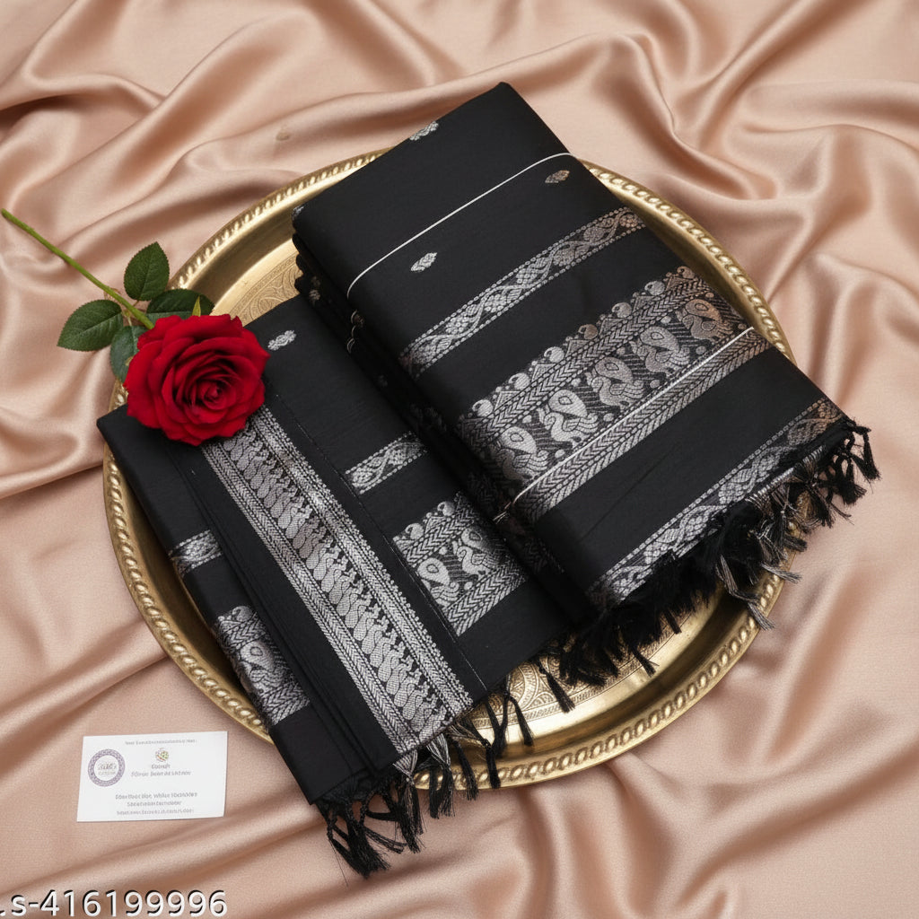 Black saree with white patterns on a textured surface with flowers and a statue.