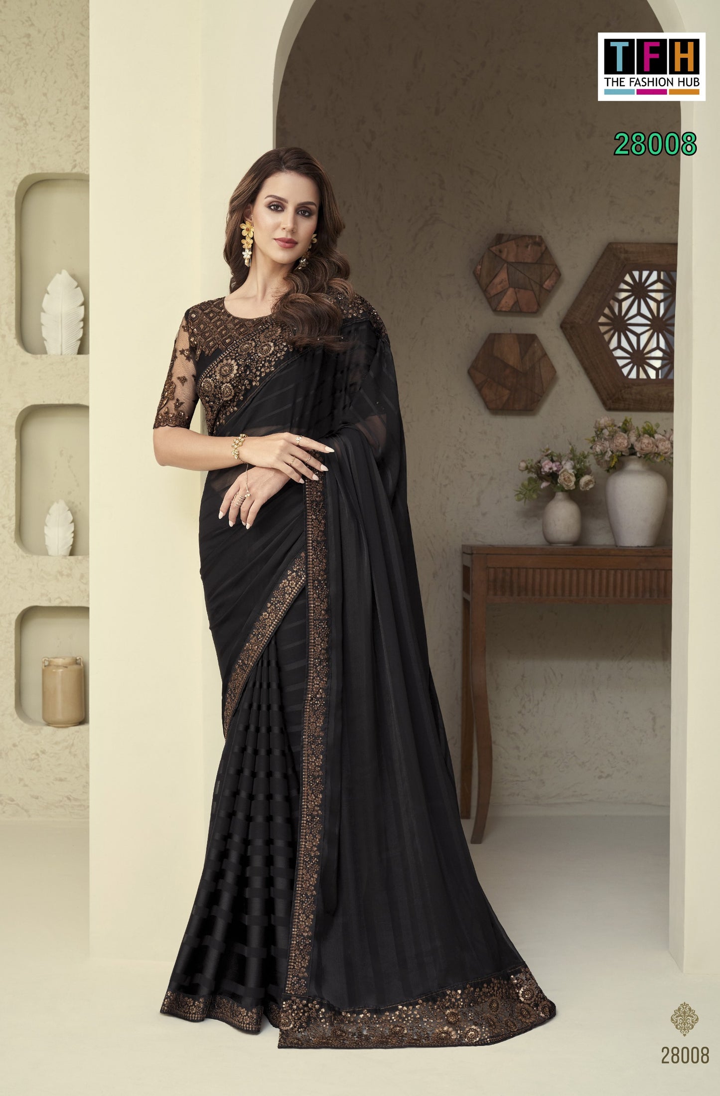 Woman wearing a black saree with gold border in an indoor setting