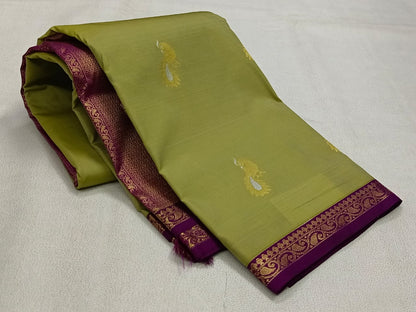 Green saree with purple border on a light gray background