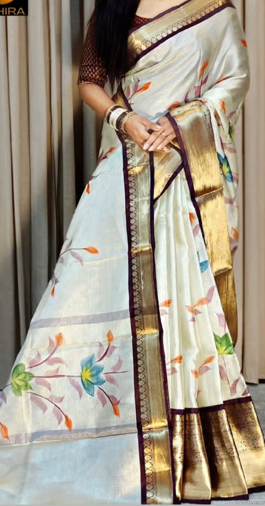 Woman wearing a traditional saree with floral patterns and a gold border.