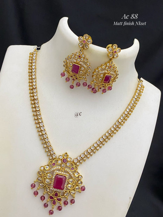matti finish necklace with red gemstones on a white mannequin against a black background