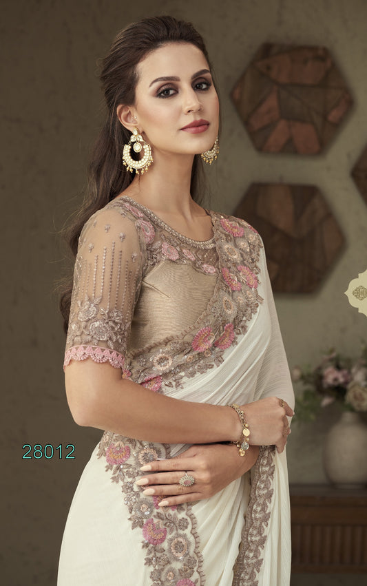 Woman wearing a saree with intricate embroidery in a decorative setting