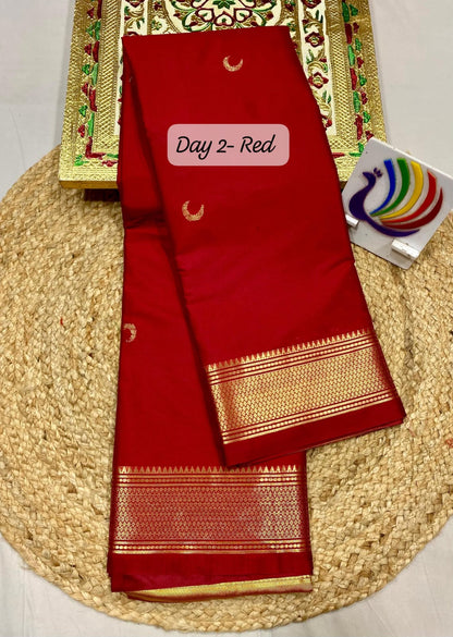 Red saree with gold border on a woven mat, with a visible brand tag.