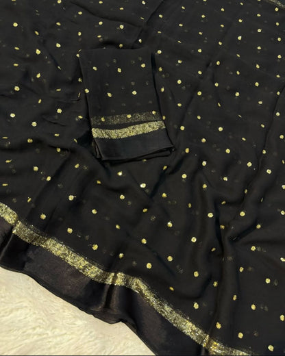 Black fabric with gold polka dots and border on a textured surface