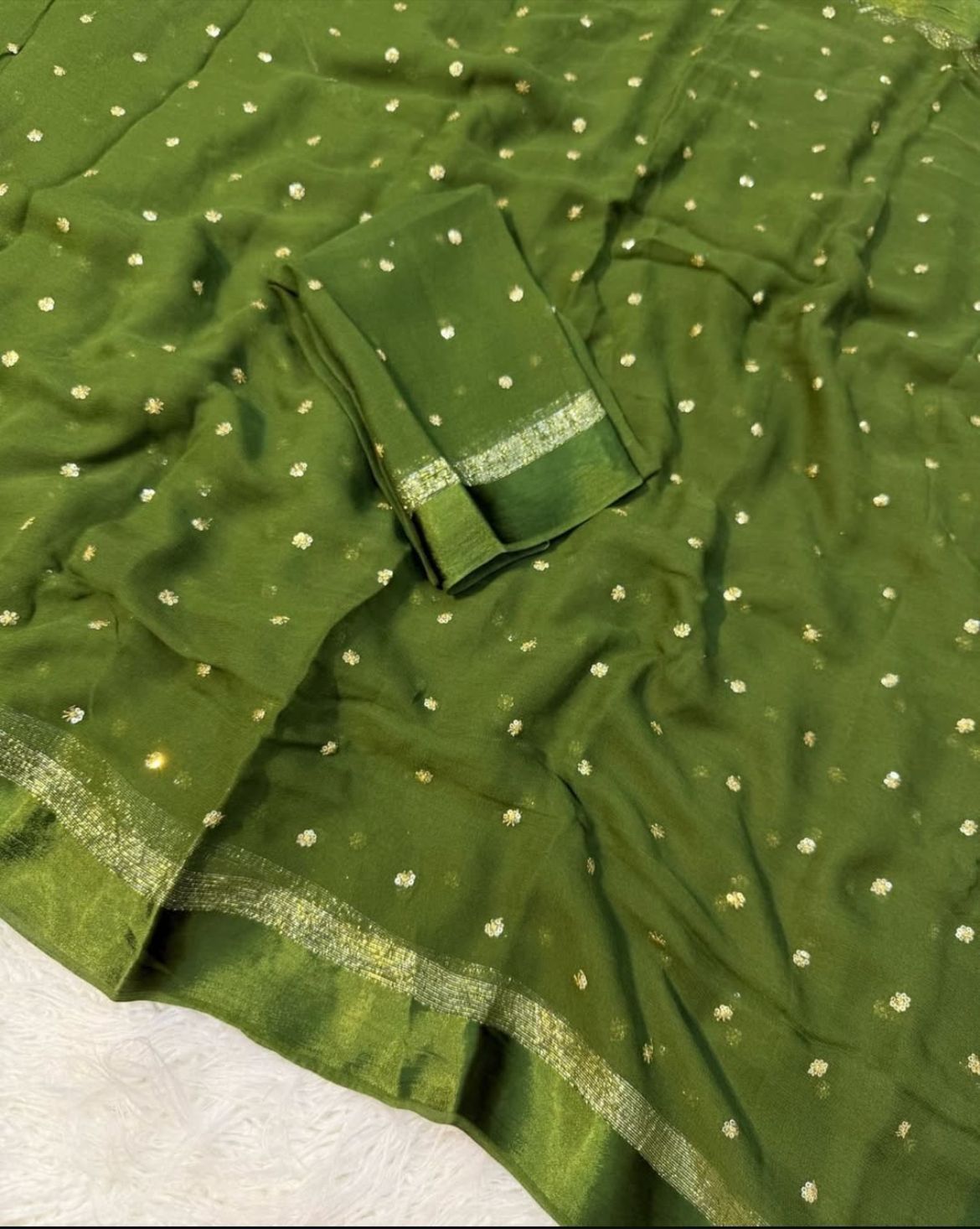Green fabric with gold polka dots and border on a white background