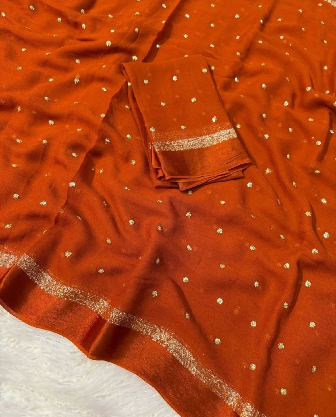 Orange fabric with gold polka dots and border on a white background