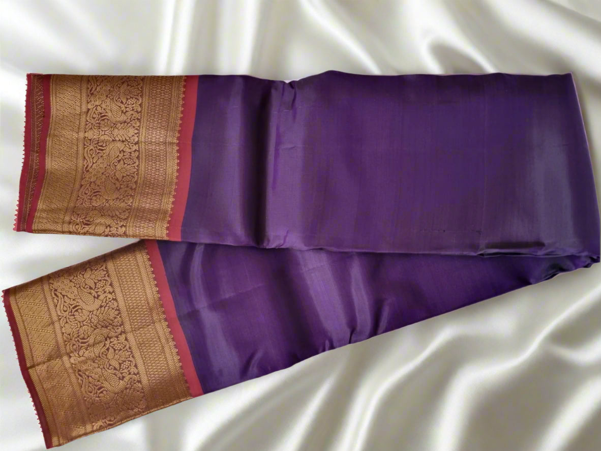 Purple saree with gold and red border on a white background