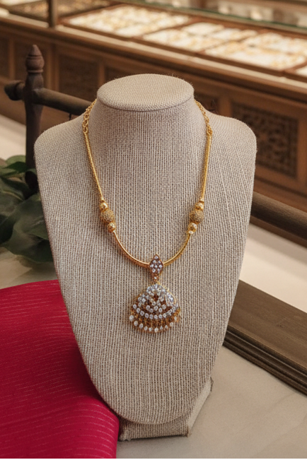 Gold necklace on a mannequin bust with a decorative background